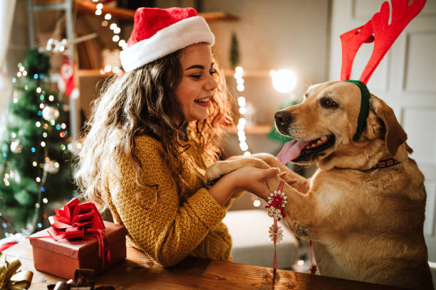 woman with dog and Santa hat over the holidays