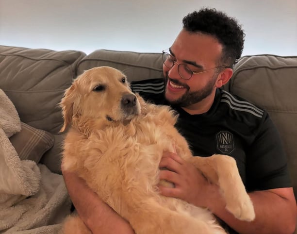 Paris cuddling a dog on the couch