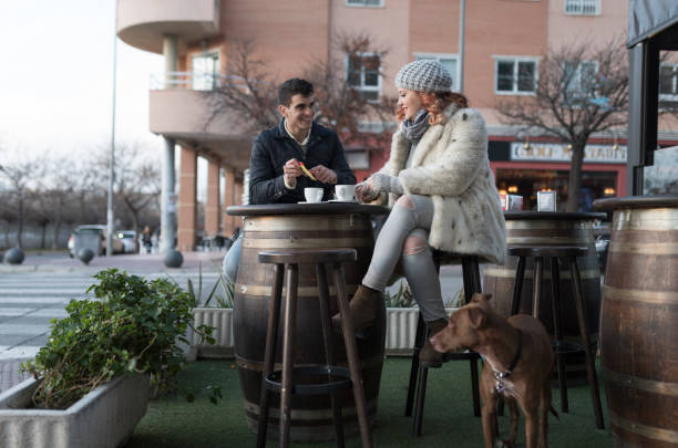 couple and dog outside on a heated patio at a dog bar in winter
