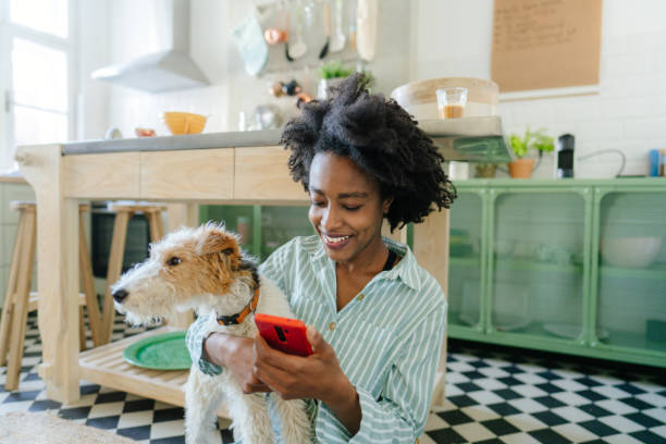 pet parent in kitchen receiving a fun text with her dog