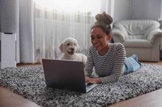 A woman and dog look at a laptop
