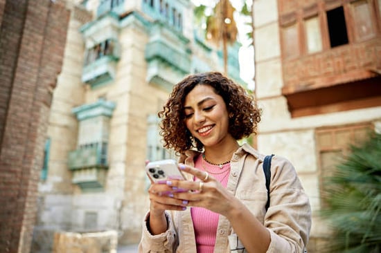 A woman uses a phone while walking outside