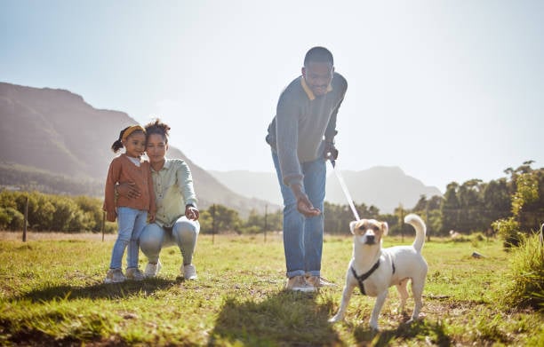 mother and child looking at dog on leash with man