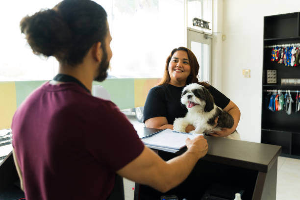 A woman checks in with her dog at the front desk of a pet business