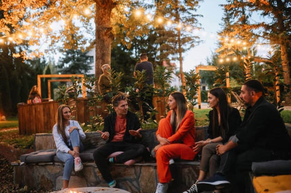 A group of people sit outside in a park at night