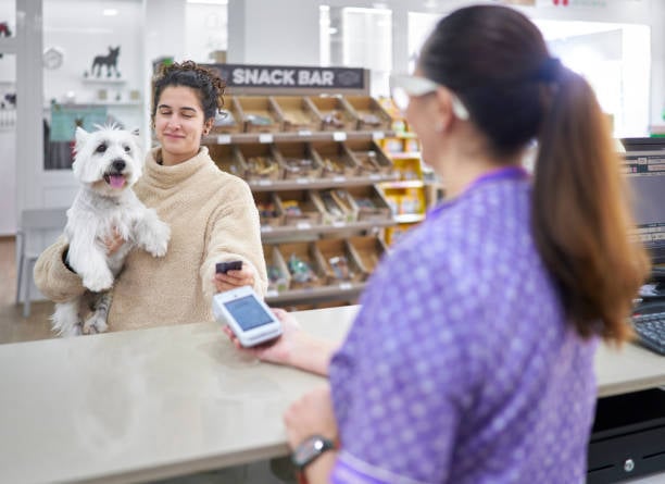 person holding dog and credit card checking out