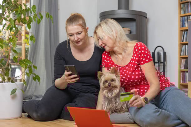 pet parents booking a service for their dog with phone, tablet, and credit card