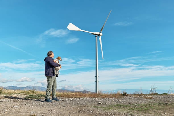 man outside with dog and green wind propeller