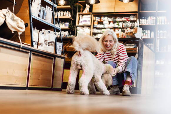 A woman pets a dog in a store