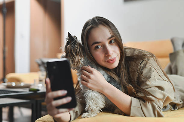 Gen Z pet parent looking at phone with dog