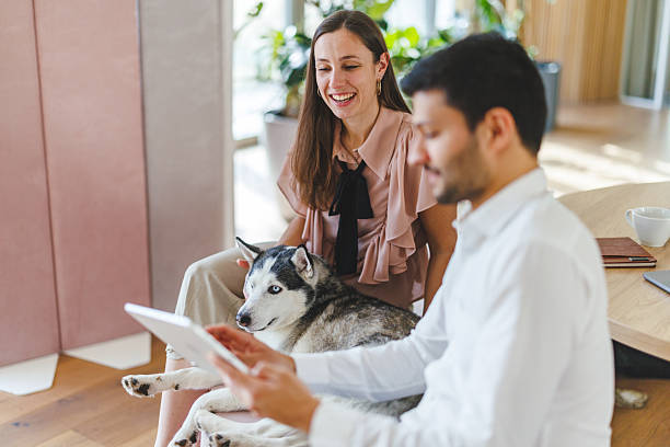 two pet parents looking at an iPad with dog