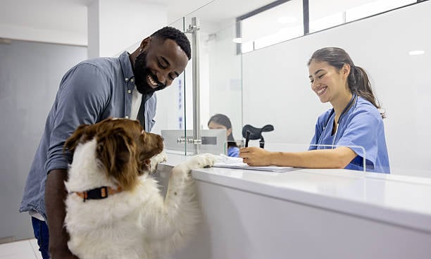 happy pet parent and dog at front desk of pet business