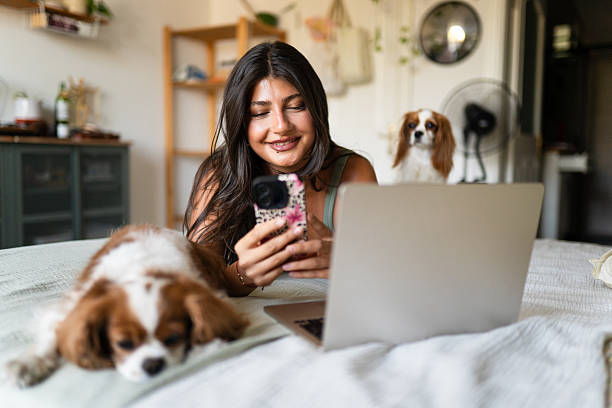 pet parent and dog inquiring with pet-care business on laptop and smartphone