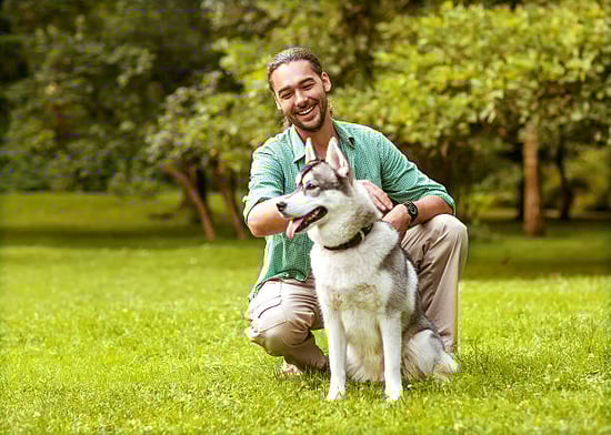 A man sits with his dog outside