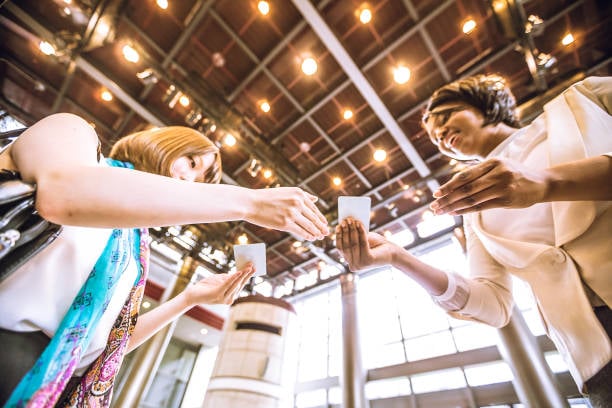 two business owners exchanging business cards at a conference or industry trade show