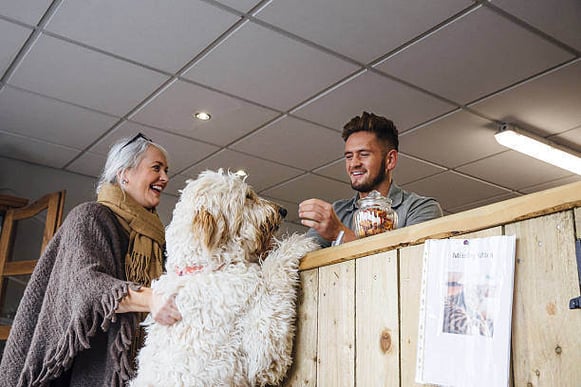 A woman checks in with her dog at a pet care business