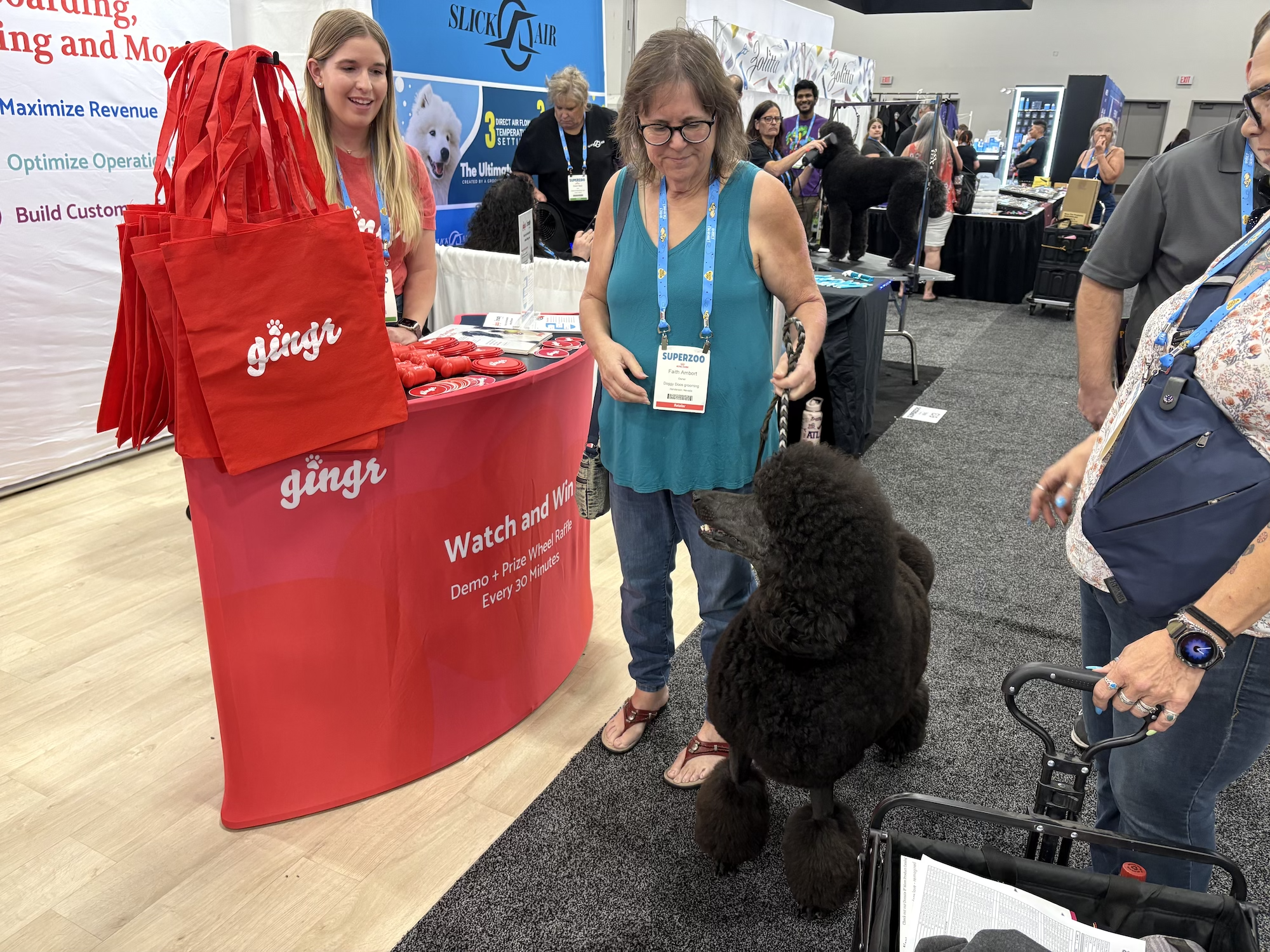 Team Gingr on site at SUPERZOO 2025 with a well-groomed poodle and pet parent