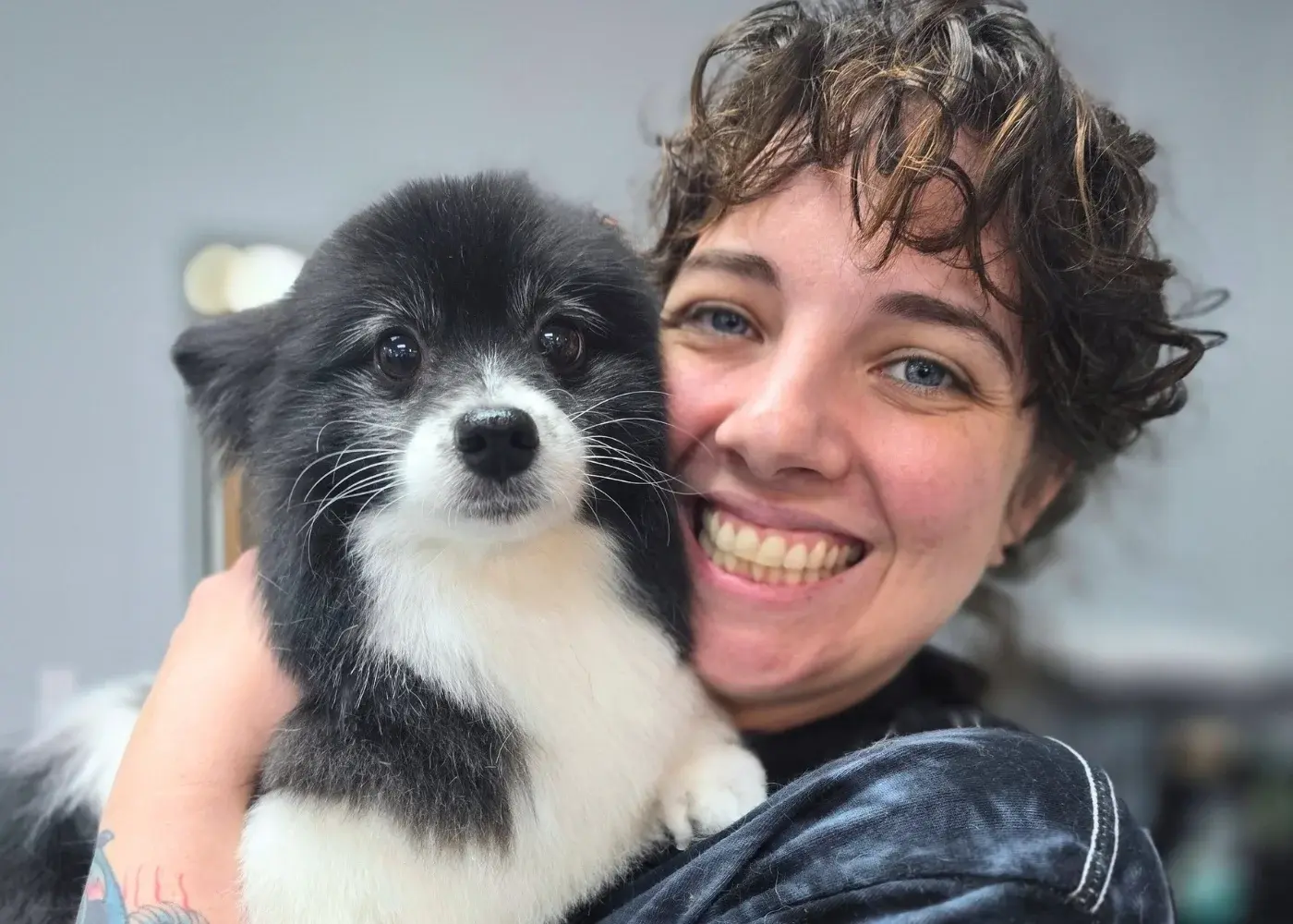 CEO, co-founder, and groomer Amanda poses with a groomed dog